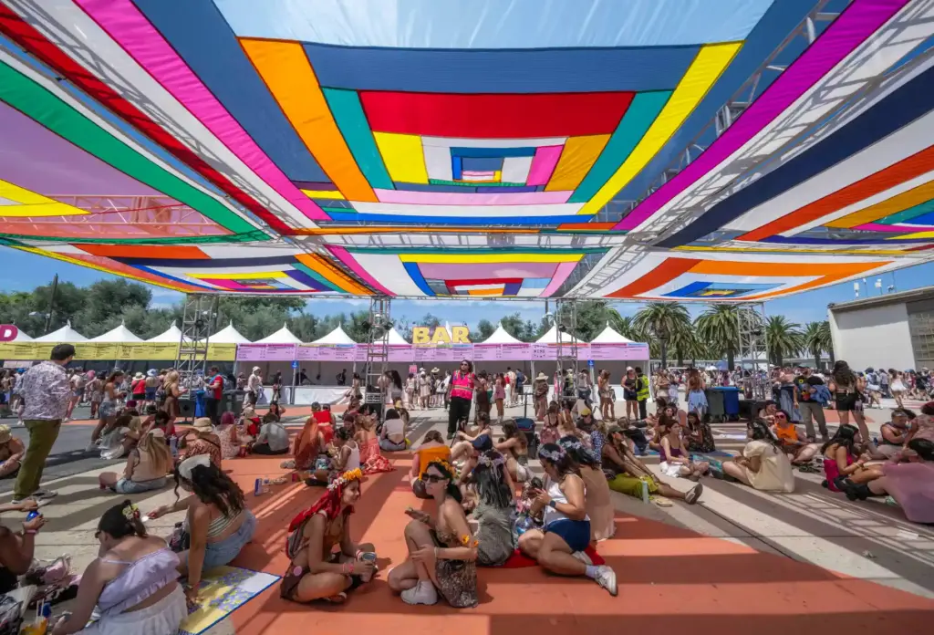 Festivalgoers rest under a brightly-colored canopy at the Daisy Chain...