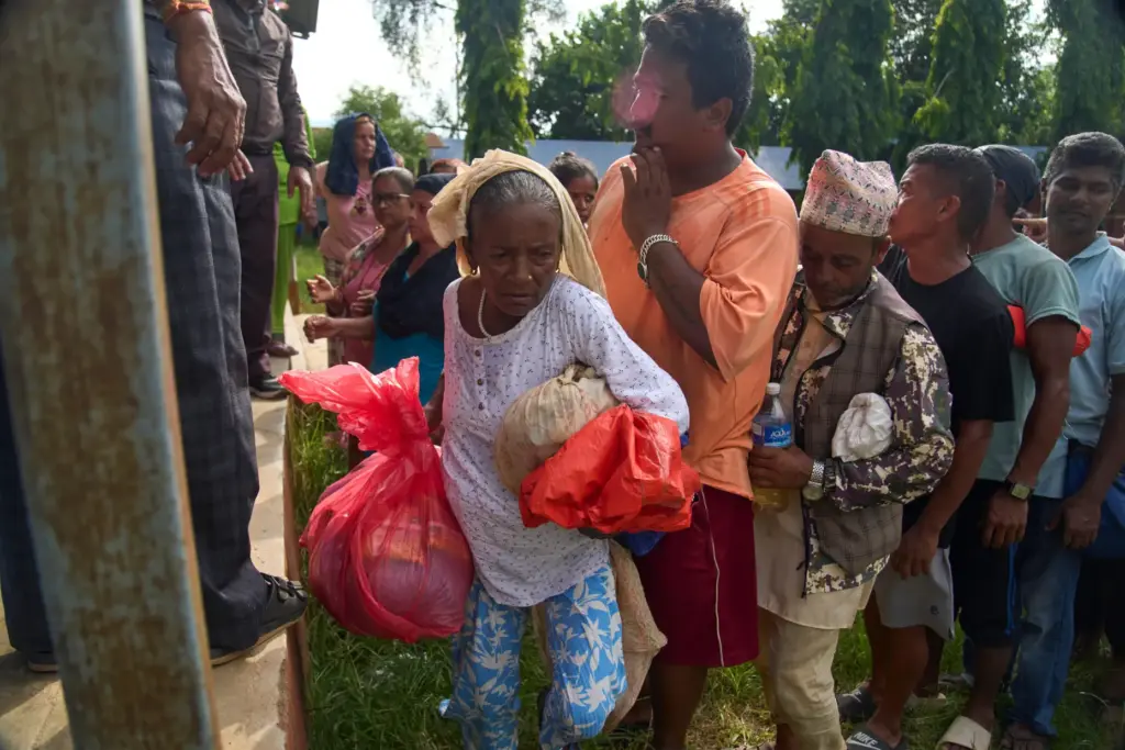 Kanchi Nepali, a survivor of flash floods, receives relief supplies...