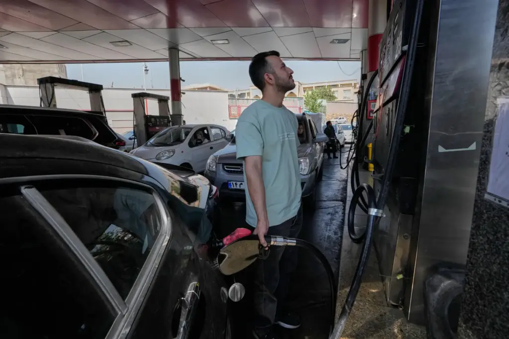 A man is filling up his car at a gas...