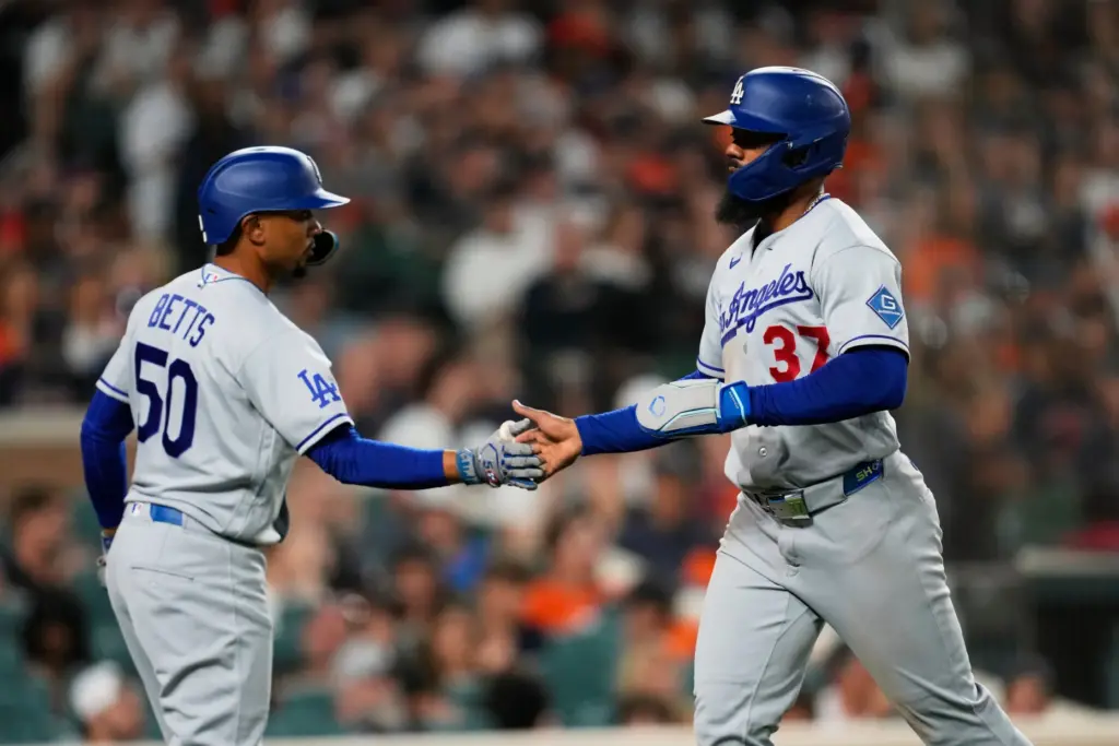 The Dodgers’ Teoscar HernÃ¡ndez (37) celebrates scoring with Mookie Betts...