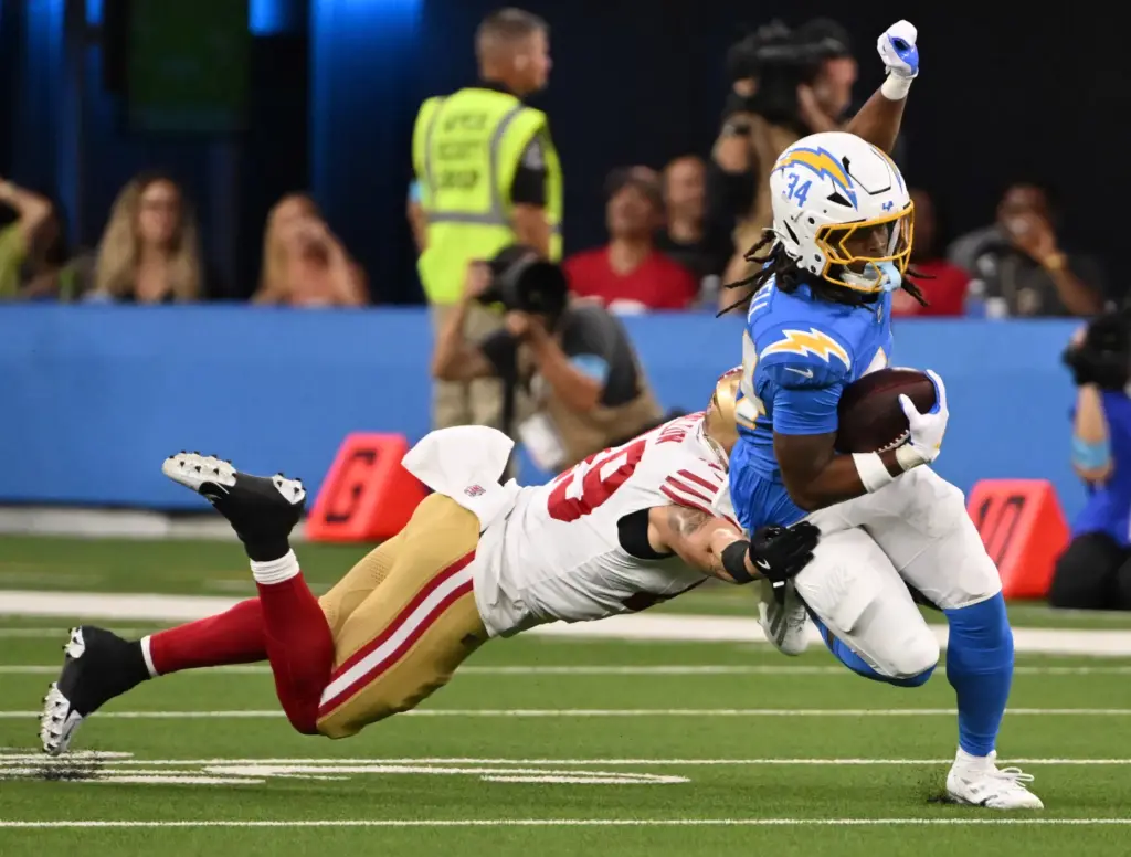Chargers running back Keaton Mitchell, right, runs for a first...