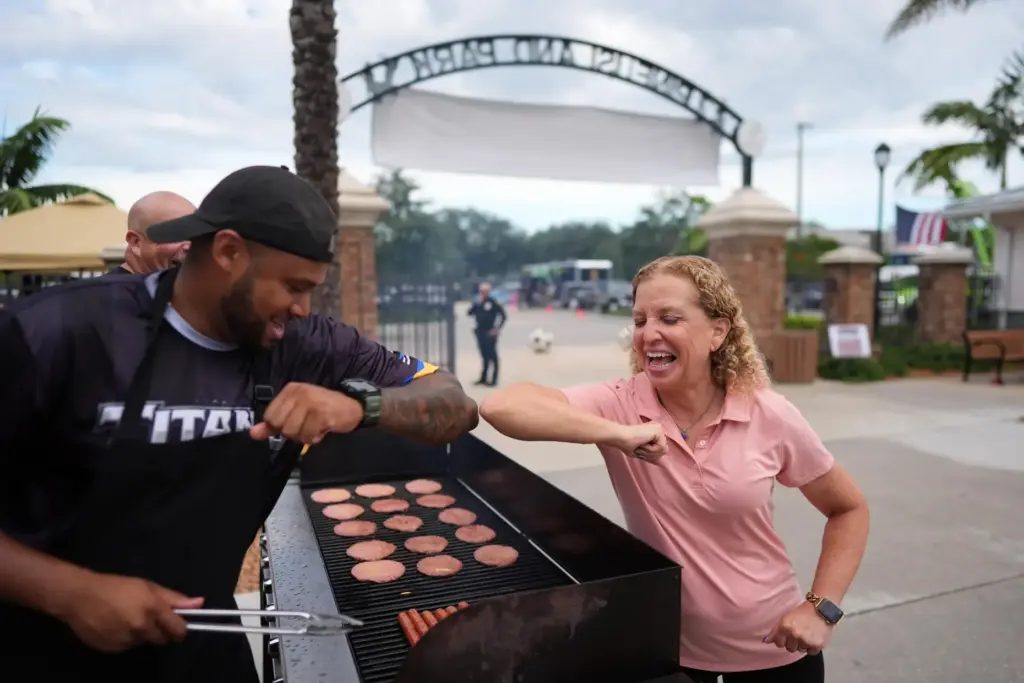 Rep. Debbie Wasserman Schultz greets a man tending to a grill.