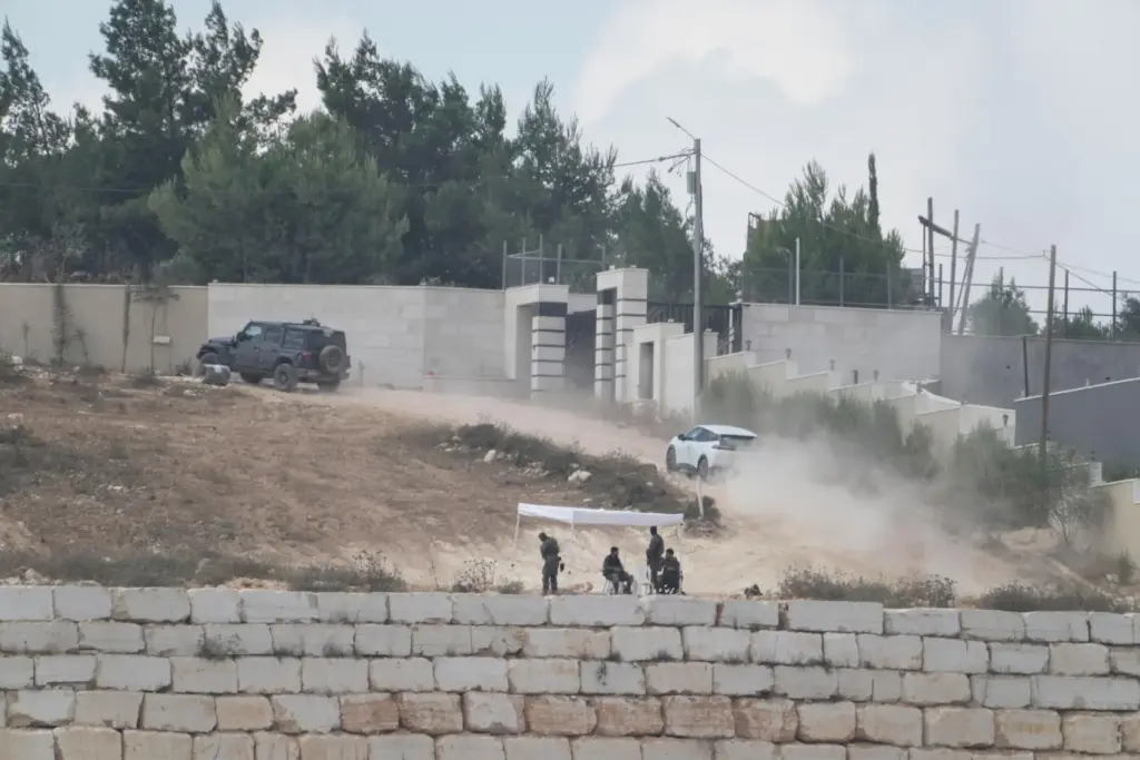 Israeli soldiers sit under a tent in front of Loui Ridi's house.