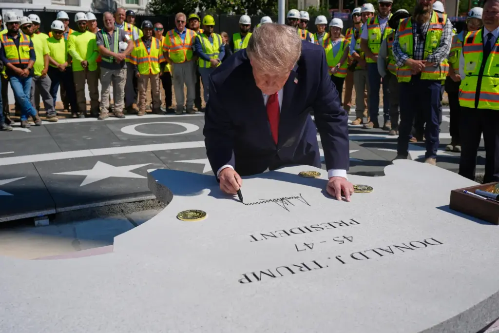 President Donald Trump signs a stone outside the White House,...