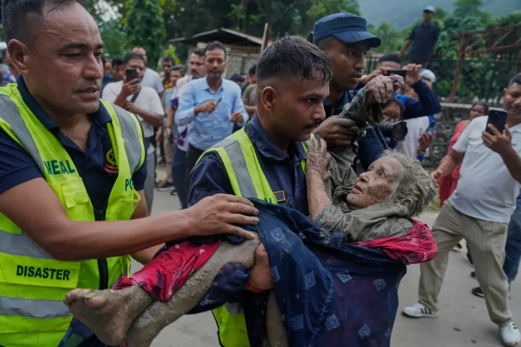 Rescuers carry a victim of flash flooding to safety along...