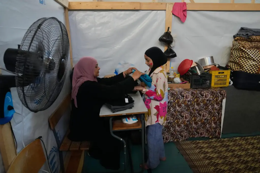 Displaced Randa al-Taki, 51, and her daughter Fatima Khashab, 11,...