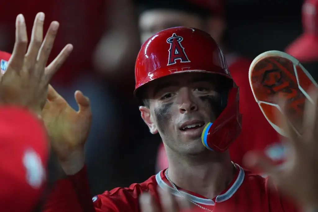 Angels’ Zach Neto is congratulated in the dugout after scoring...