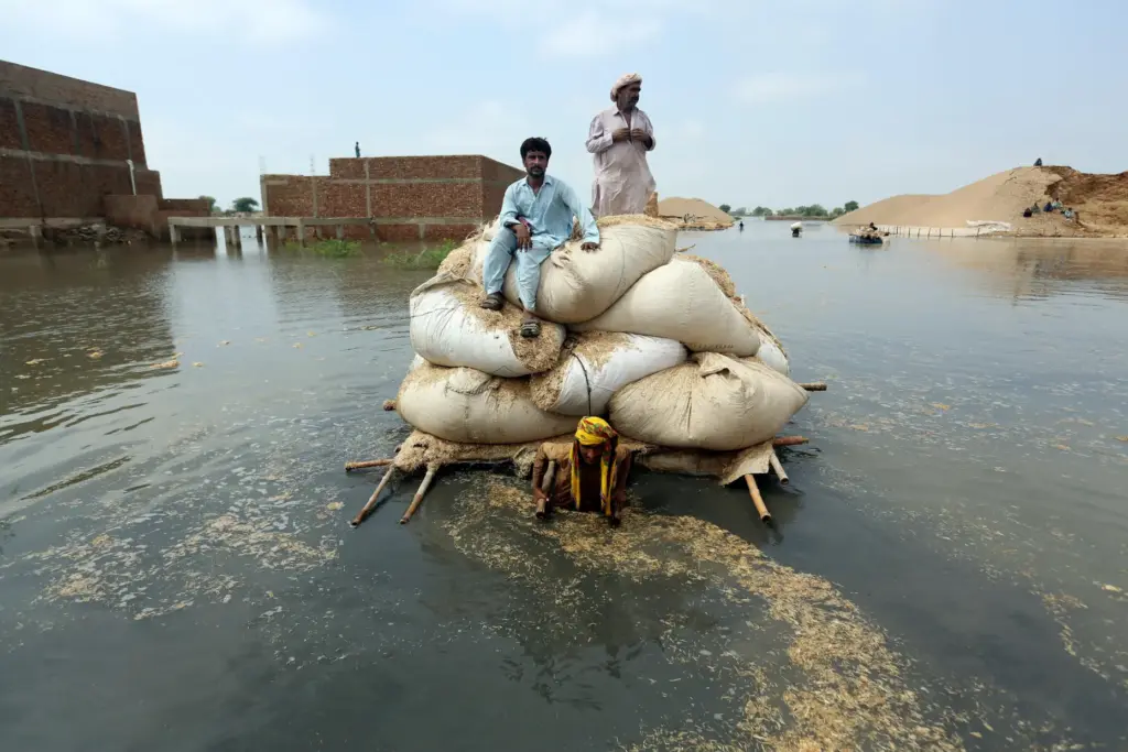 Victims of the unprecedented flooding from monsoon rains use a makeshift barge.