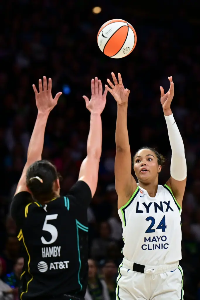 Minnesota Lynx forward Napheesa Collier, right, shoots as Sparks forward...