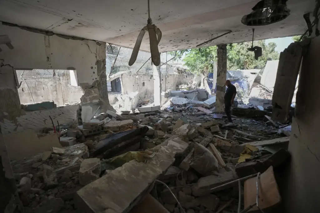 Palestinians inspect the damage at a police station that was hit by an Israeli airstrike.