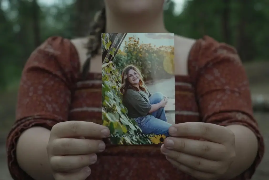 Charlotte Touzalin holds a photo of herself, provided by Bre...