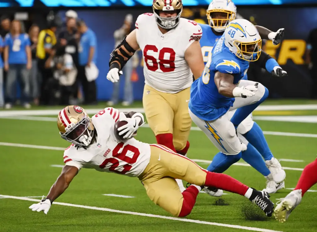 San Francisco 49ers running back Kaelon Black dives for yardage...