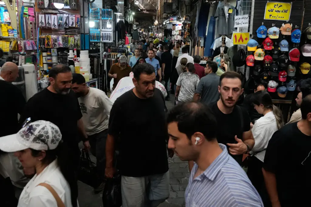 People walk in Tehran’s traditional main bazaar, Iran, Saturday, Aug....