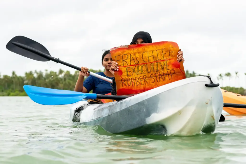 A participant holds a sign as part of Project ThimaaVeshi,...