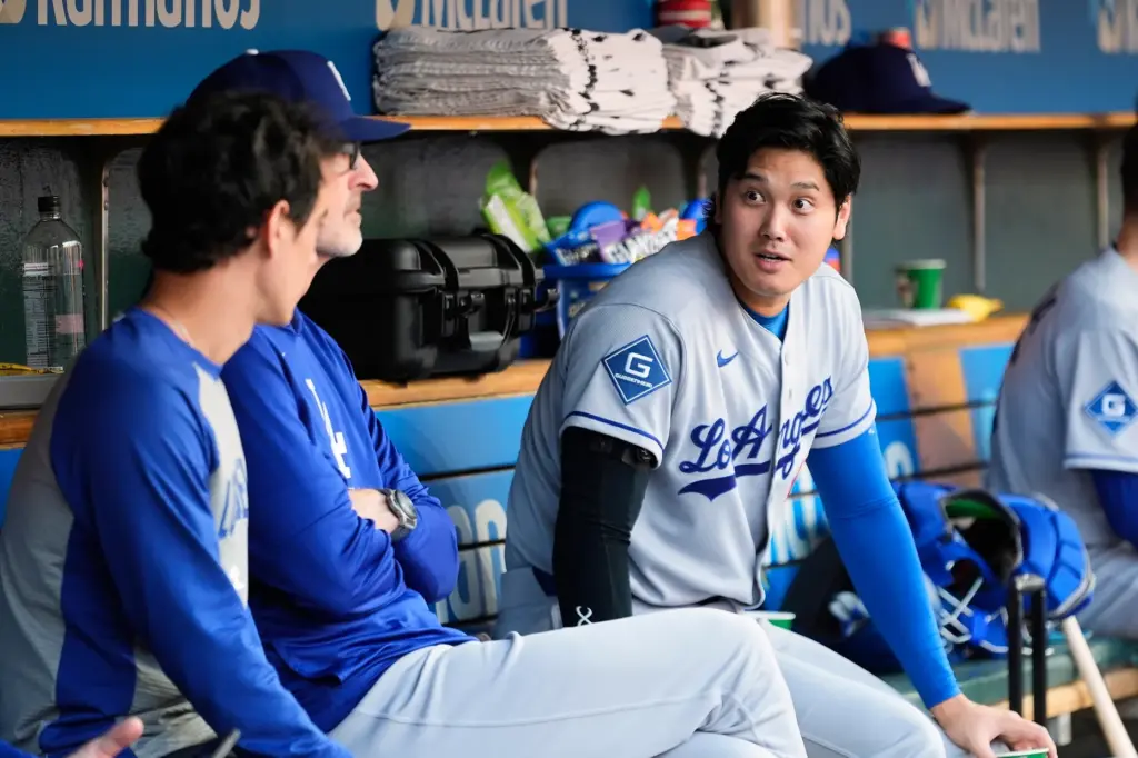 Dodgers star Shohei Ohtani talks in the dugout during the...