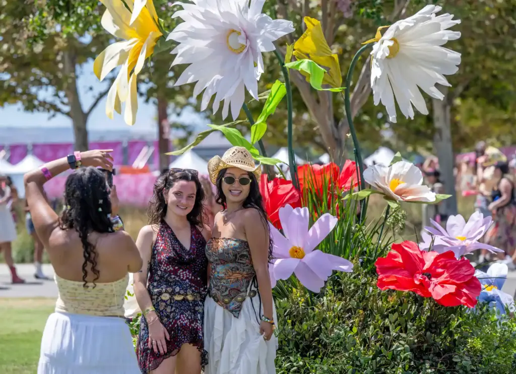 Festivalgoers pose in front of giant daisies at the inaugural...