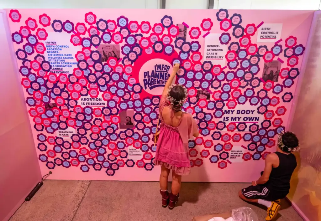 Festivalgoers place messages of support on a wall at a...