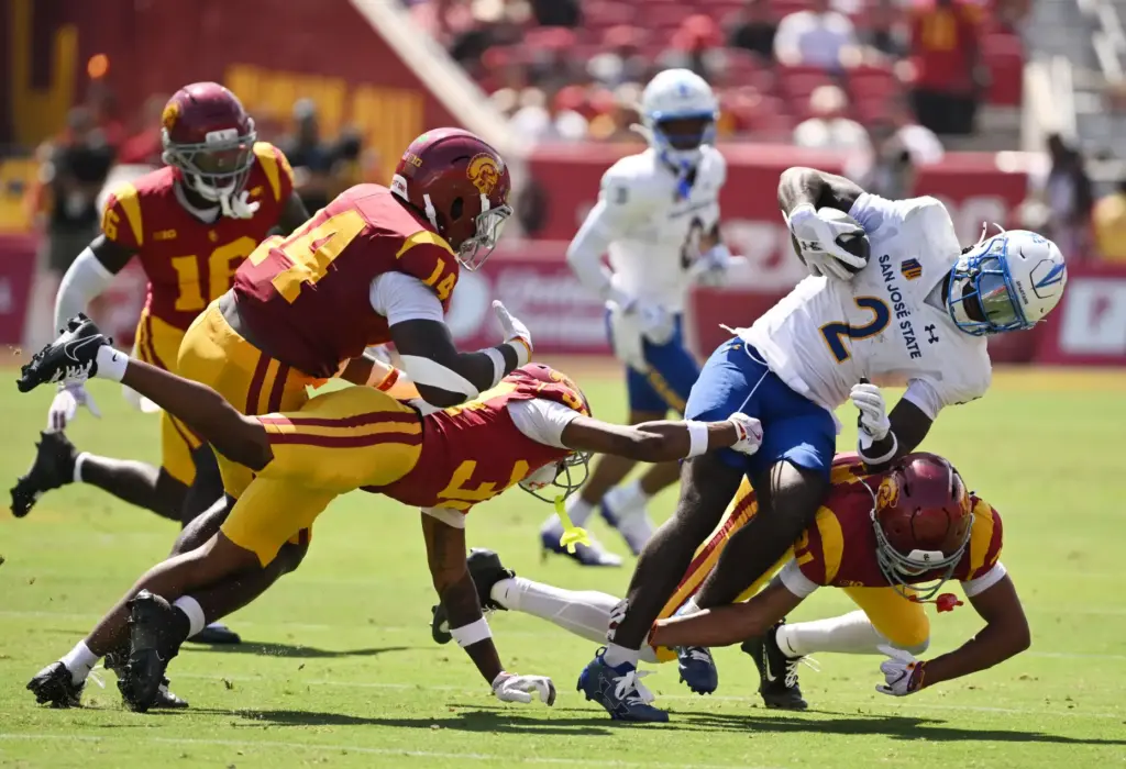 Cornerback RJ Sermons (21) of the USC Trojans tackles wide...