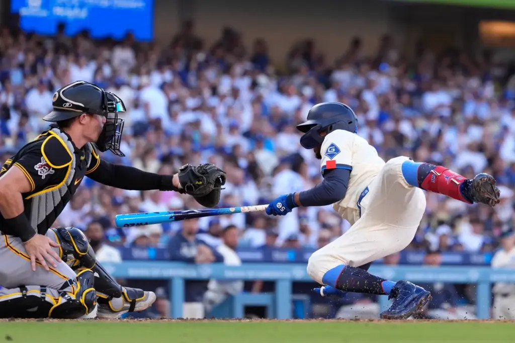 Dodgers’ Mookie Betts, right, falls after being hit by a...