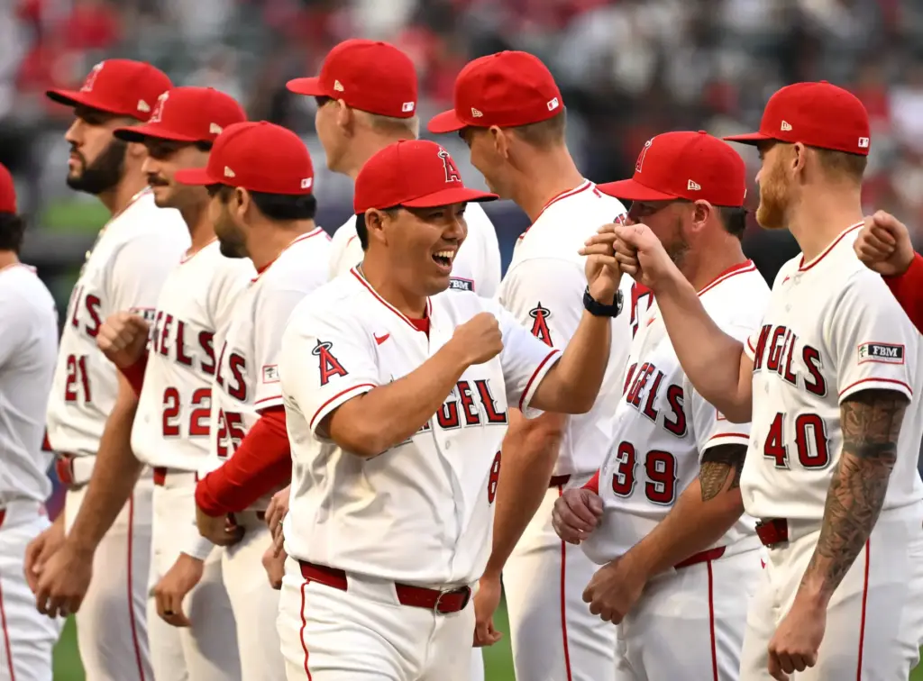 Angels manager Kurt Suzuki (8) greets his players during pregame...