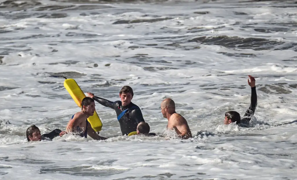 Lifeguards work to rescue a swimmer in the surf at...