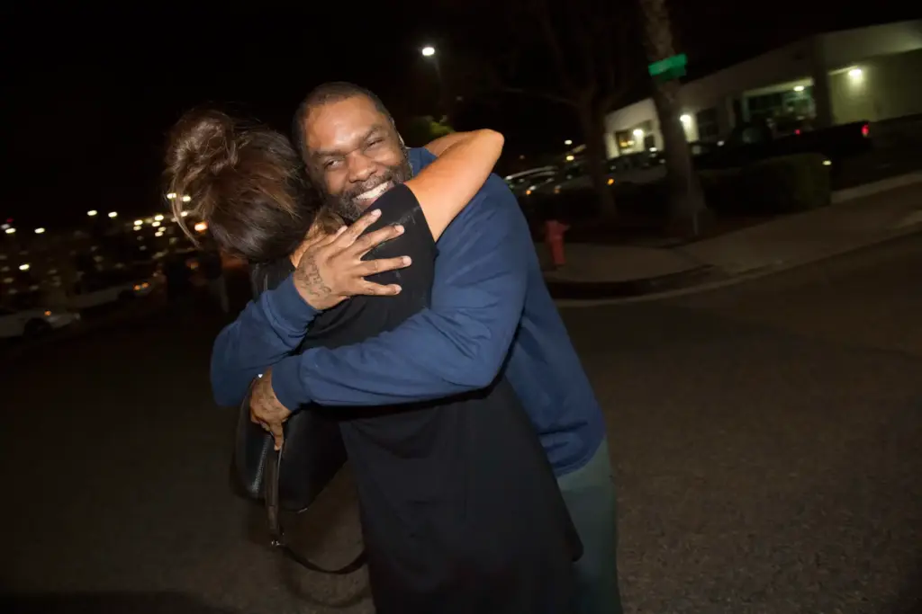 Guy Miles hugs attorney Raquel Cohen of the California Innocence...