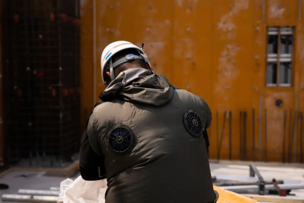 FILE – An employee works at a construction site wearing...