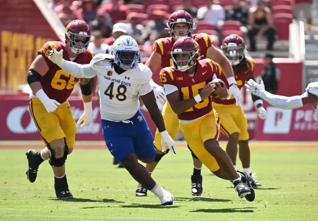 Quarterback Jonas Williams (15) of the USC Trojans scrambles for...