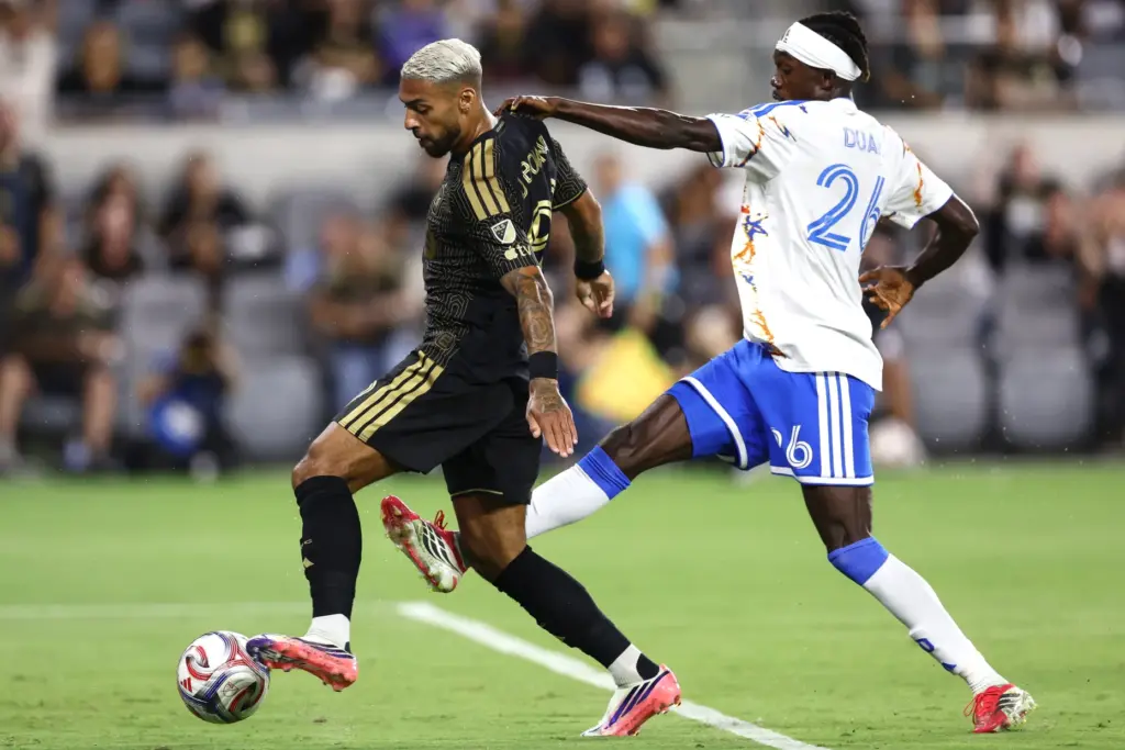 Los Angeles FC forward Denis Bouanga, left, is pulled by...