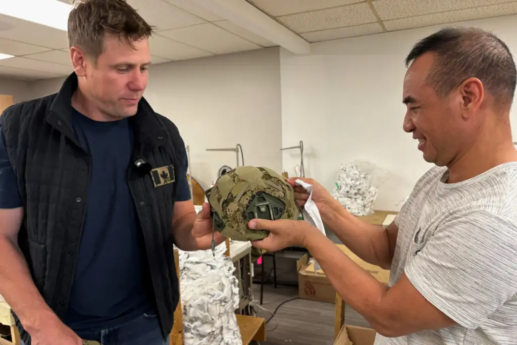 Wuxly CEO James Yurichuk and garment factory owner Aaron Ly inspect military helmet covers.