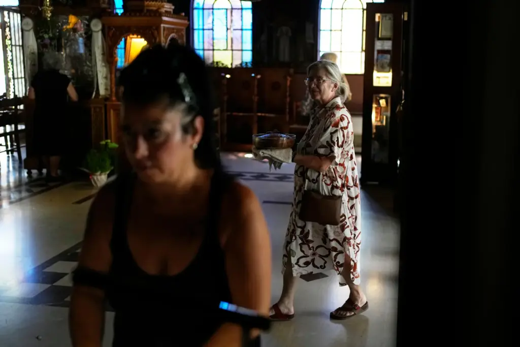 Maria Chanioti carries Fanouropita, an orange-flavored cake, to be blessed.