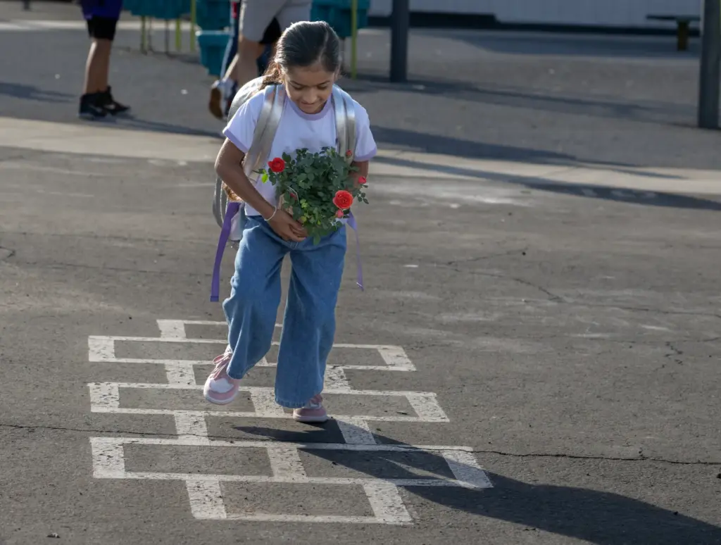 Lara Patel, 5, multitasks while playing hopscotch while holdingÂ roses for...