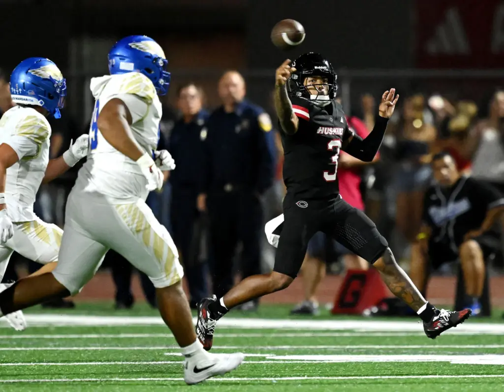 Centennial quarterback Jaden Jefferson (3) roles out and passes against...