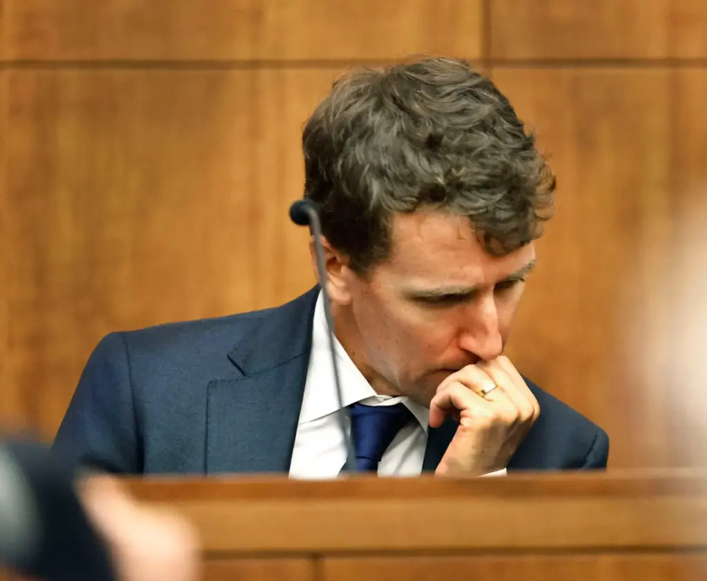 Patrick Clancy reacts as images of himself and his children on vacation are shown in court.