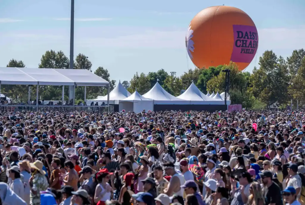 Thousands of festivalgoers fill the field in front of the...