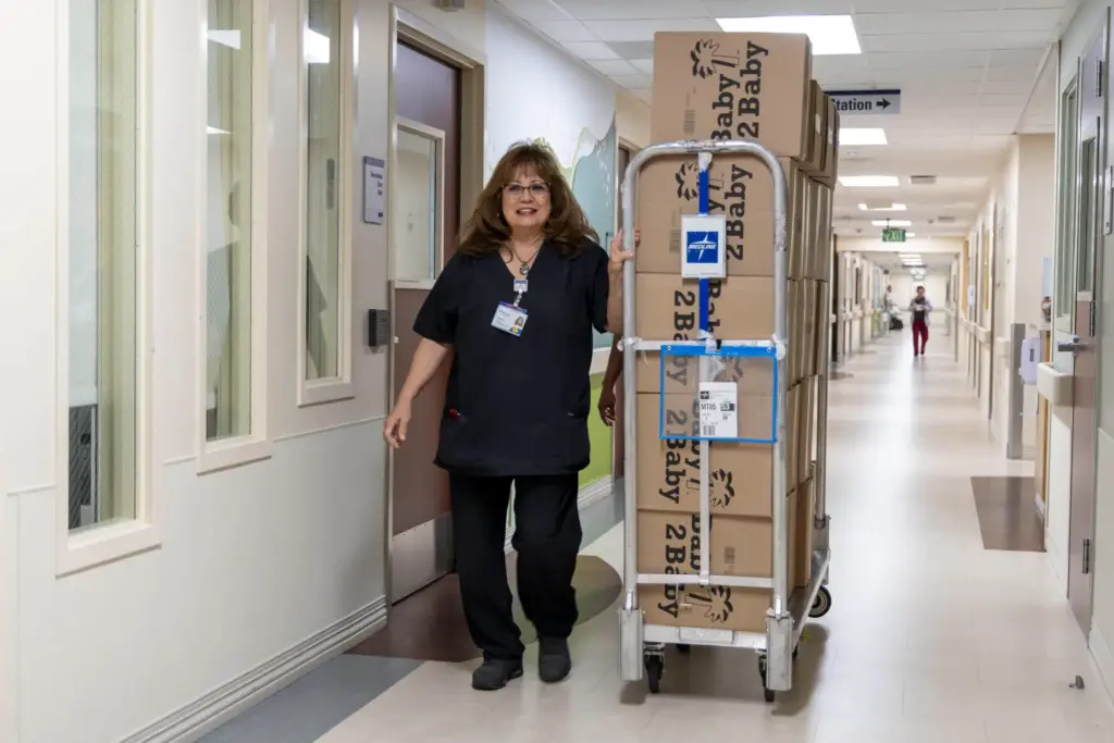 Supply Chain Supervisor Teresa Bassaline pushes a cart of diapers...