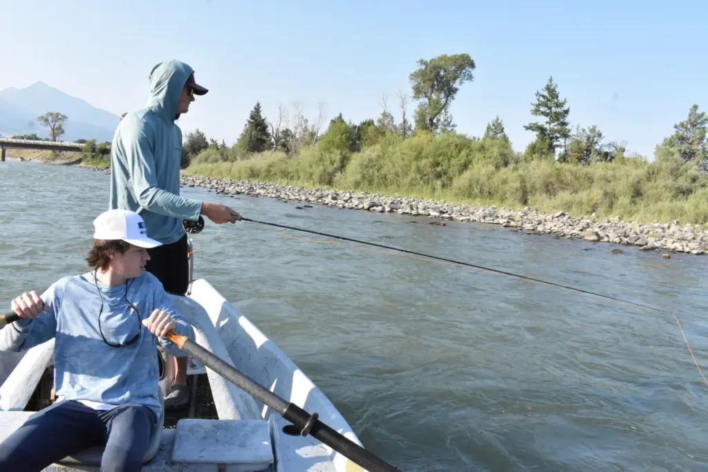 Marek Senn fishes for trout while Jase Joslin rows their...