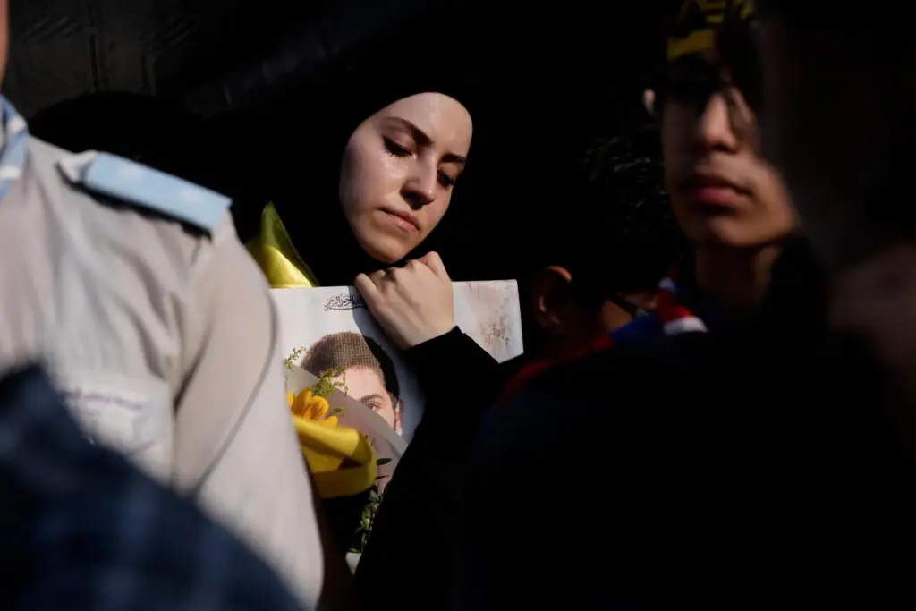 A woman mourns during the funeral of Hezbollah member Ali al-Haj Hassan, his wife and children.