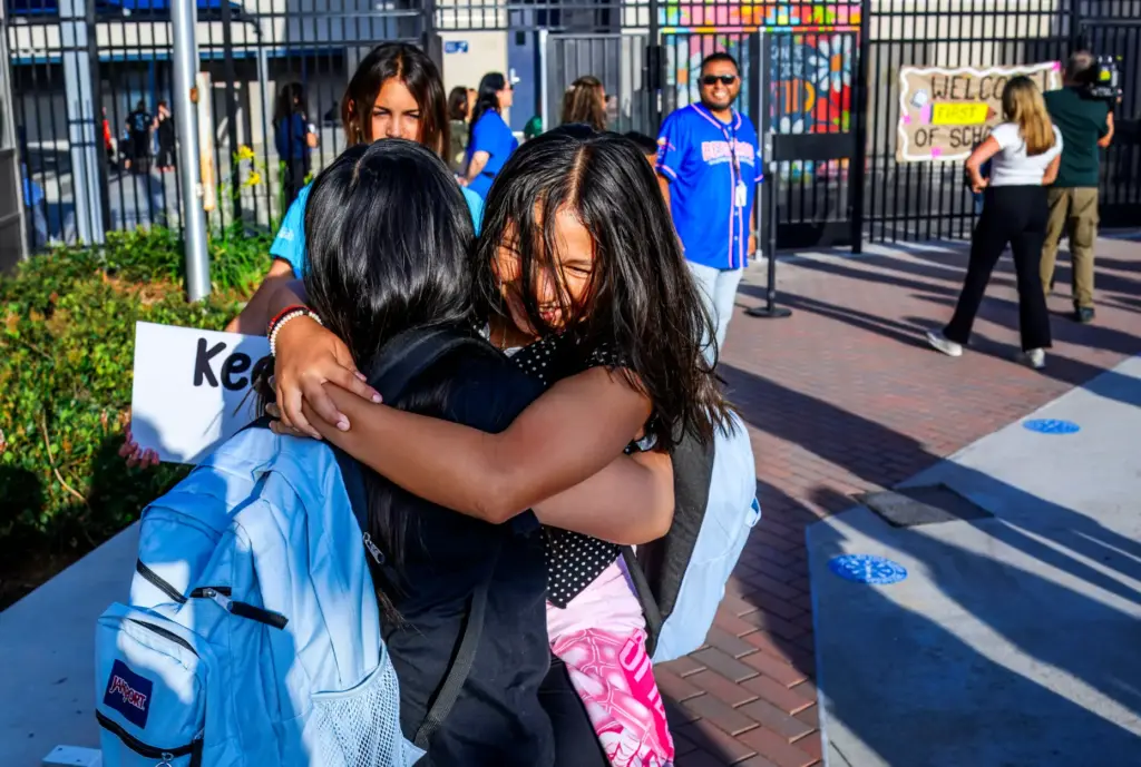 Lilianna Gulley, 11, right, excitedly hugs a friend as she...
