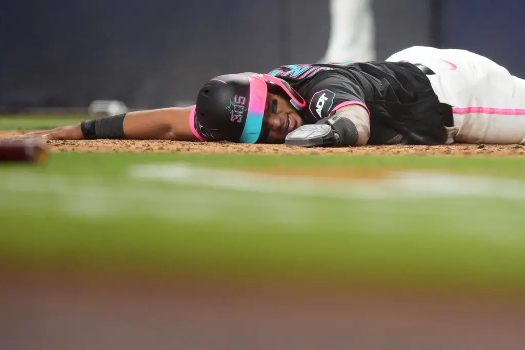 The Miami Marlins’ Leo Jimenez lies on the ground after...