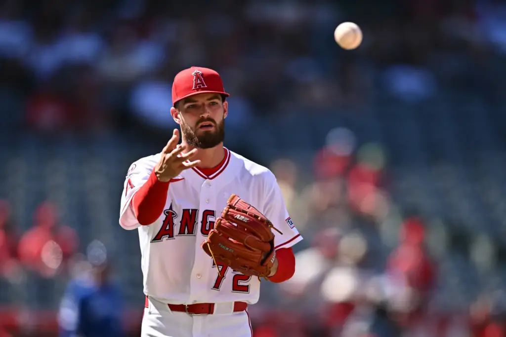 Angels pitcher Luke Murphy throws to first base after fielding...