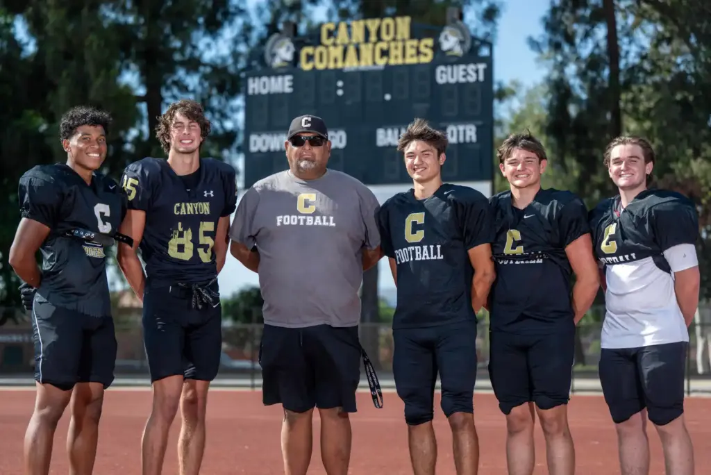 Canyon High School head football coach Vinnie Lopez stands with...