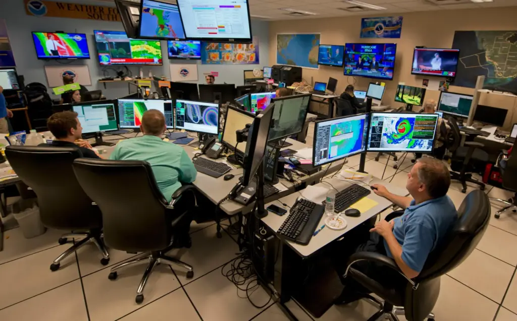 FILE – Forecasters at the National Weather Service office monitor...