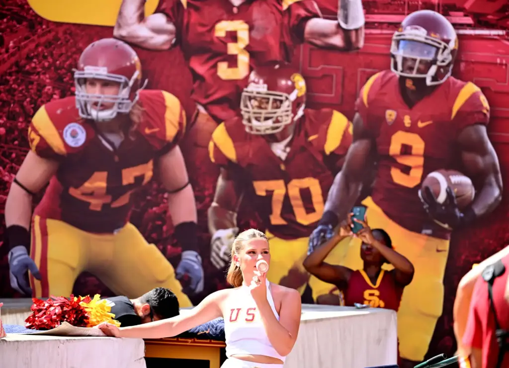 A USC Song Leader tries to stay cool using a...