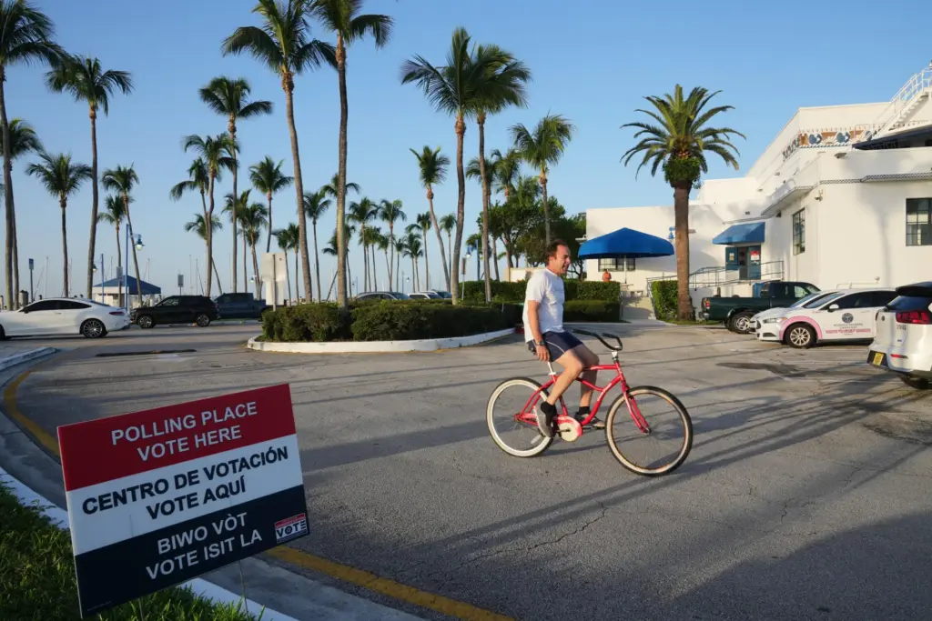 A cyclist rides past a voting precinct at Miami City...