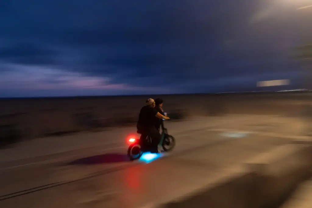 An adult rides an e-bike with a child in Santa...