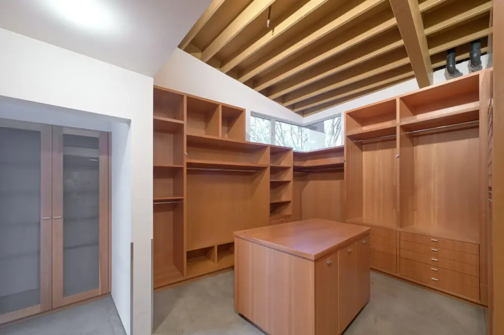 The boutique-style primary walk-in closet features custom woodwork beneath the...