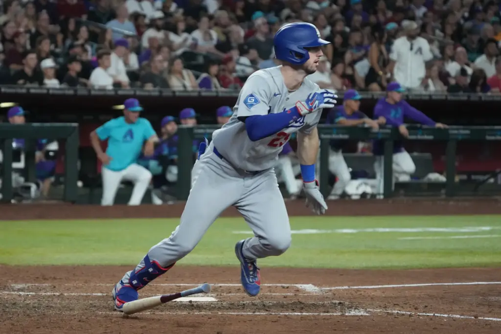 The Dodgers’ Tommy Edman begins to run after putting the...