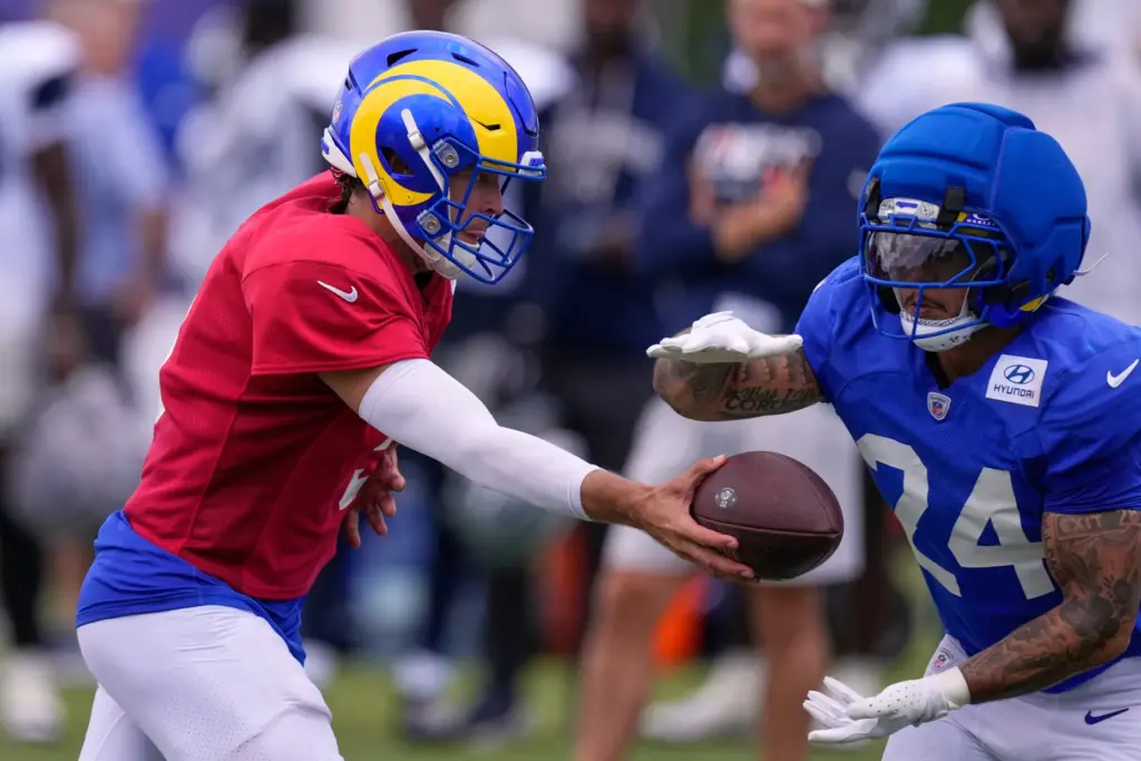 Rams quarterback Matthew Stafford, left, hands the ball off to...