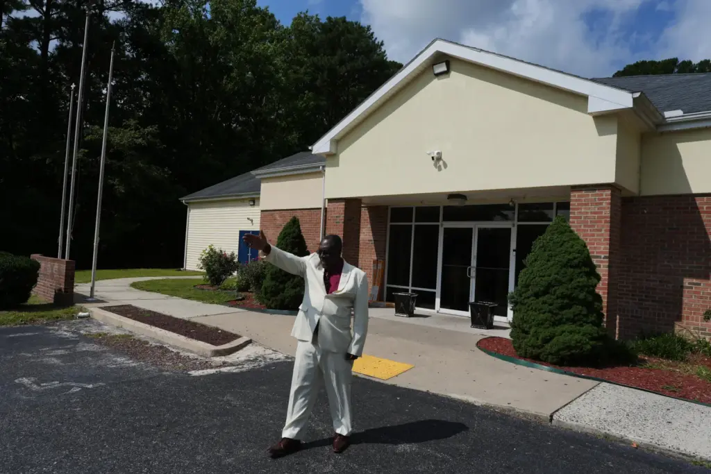 Roosevelt Toussaint points to empty parking spaces outside his church.